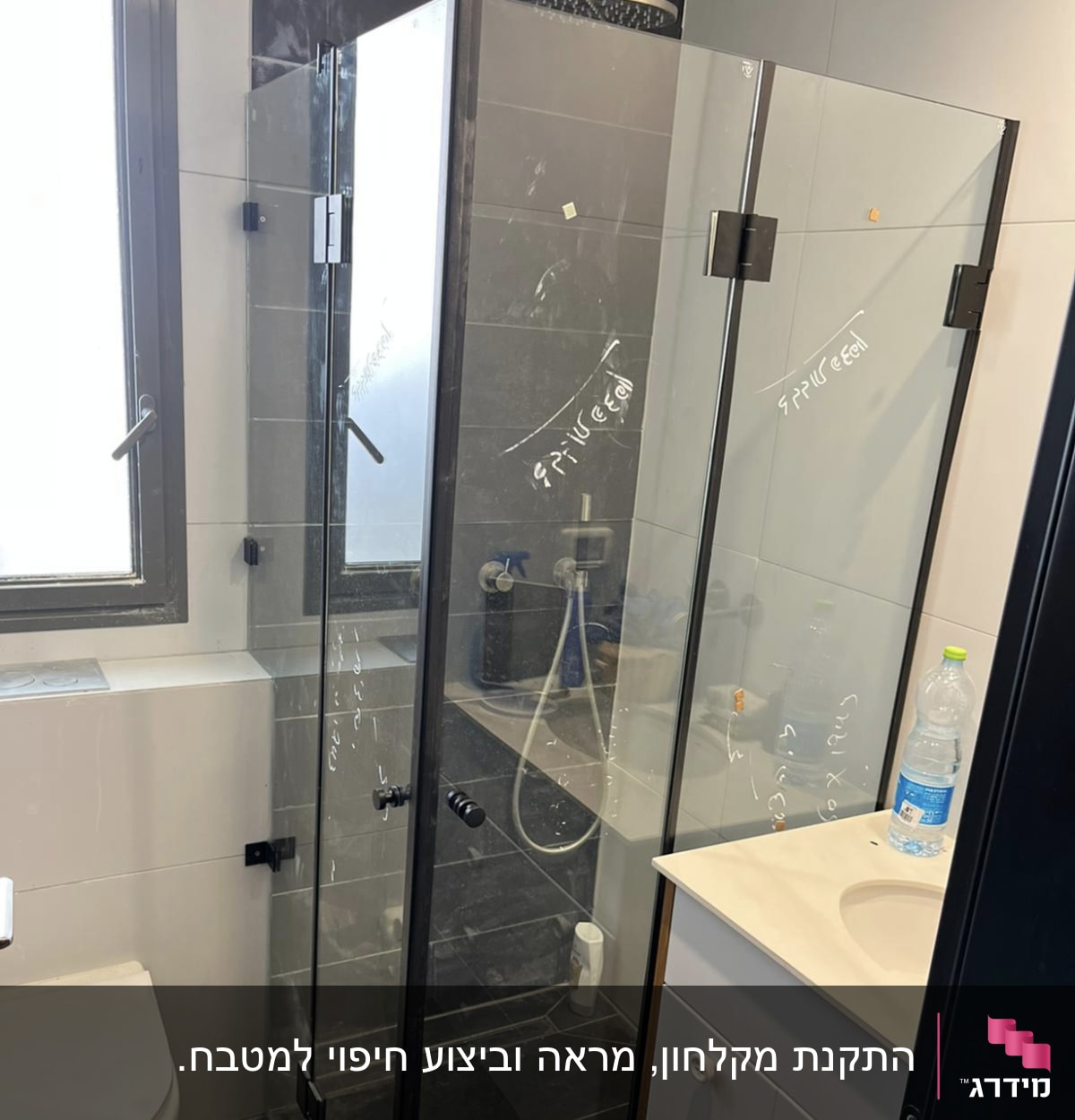 מקלחון זכוכית עם דלתות שקופות ומסגרת שחורה
